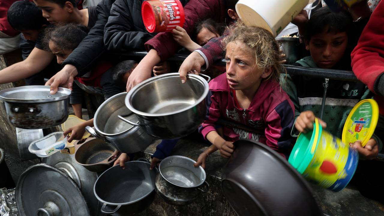 গাজার রাফাহ অঞ্চলে খাবার সংগ্রহ করতে আসা বাস্তুচ্যুত ফিলিস্তিনিদের ভিড় / ছবি: এএফপি