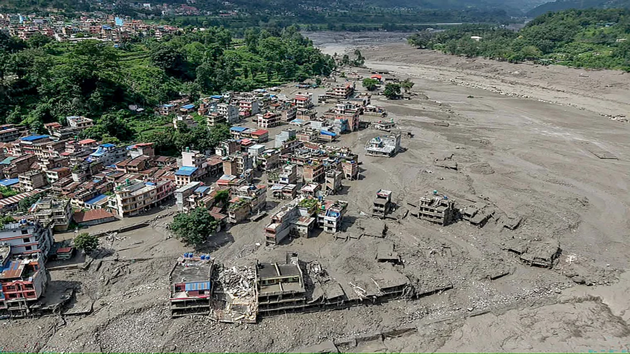 আকস্মিক বন্যার পর নদীর তীরে কাদাপানিতে আংশিক তলিয়ে রয়েছে ঘরবাড়ি। সড়ক ও বিদ্যুৎ অবকাঠামো মারাত্মকভাবে ক্ষতিগ্রস্ত হয়েছে। ত্রিশূলী বাজার, নুয়াকোট, নেপাল। ২৬ আগস্ট ২০২৬ছবি: এএফপি